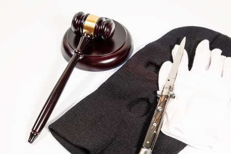 Judge's mallet next to criminal balaclava and knife on white background. SELECTIVE FOCUS.の写真素材