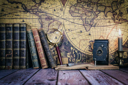 still life composed of antique books, camera and clock on a background of a classic map.の写真素材