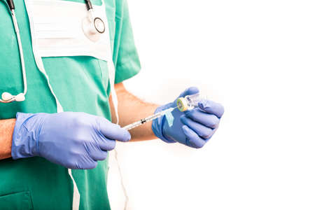 Male nurse carrying vaccine or medication in syringe with safety needle, dressed in green scrubs on white background.の写真素材
