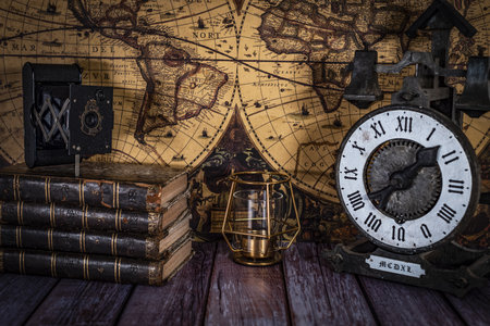 still life composed of antique books, camera and clock on a background of a classic map.の写真素材