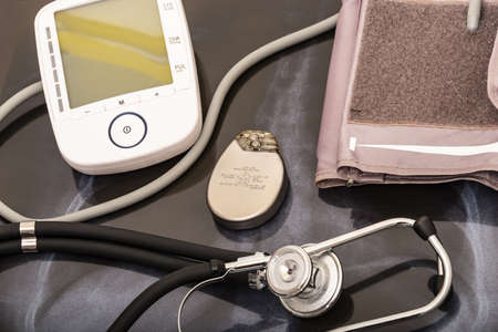 still life of a stethoscope with pacemaker battery and heart pressure measuring device together with medical objects.の写真素材