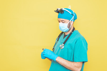 young doctor-surgeon dressed in green on yellow background.の写真素材