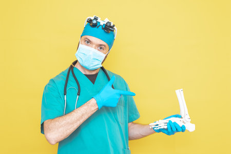 young doctor-surgeon dressed in green on yellow background.の写真素材