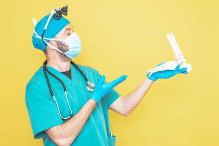 young doctor-surgeon dressed in green on yellow background.の写真素材