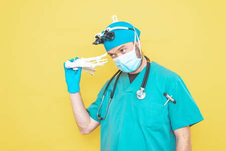young doctor-surgeon dressed in green on yellow background.の写真素材