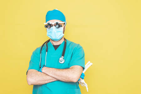 young doctor-surgeon dressed in green on yellow background.の写真素材