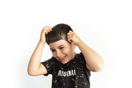 caucasian child expressing amusement with homework on white backgroundの写真素材