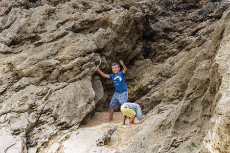 two Caucasian children playing at sunset on the beachの写真素材