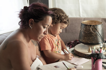 Mother and 3-year-old Caucasian son make crafts in caravan while on vacationの写真素材