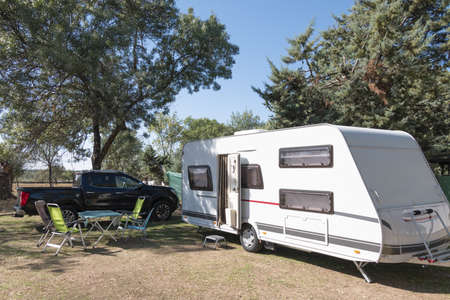 two Caucasian children play and spend alternative holidays in a caravanの写真素材