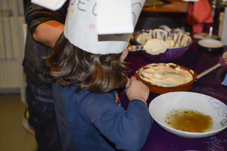 young boy baking a cake at homeの写真素材