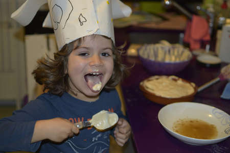 young boy baking a cake at homeの写真素材