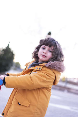 5 year old Caucasian boy rides scooter.の写真素材