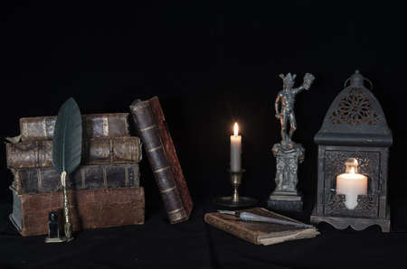 medusa statue next to antique books and candlelight.の写真素材