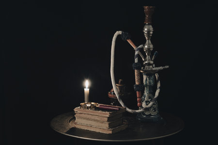 Shisha hookah together with book with candles. shisha concept.の写真素材