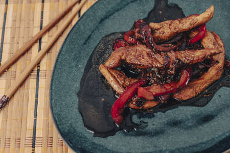 Chicken strips with red pepper in teriyaki sauce served.の写真素材