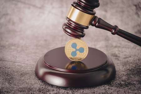 Judges gavel holding a descriptive cryptocurrency coin.の写真素材