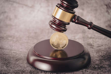 Judges gavel holding a descriptive cryptocurrency coin.の写真素材