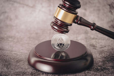 Judges gavel holding a descriptive cryptocurrency coin.の写真素材