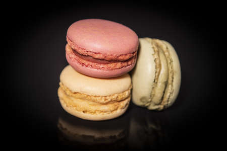 close-up of macarins of various colours on a black background.の写真素材