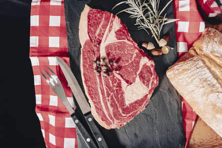 Raw fresh marbled meat Steak and seasonings on dark marble background.の写真素材