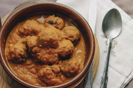 Meatball stew with tomato sauce in earthenware casserole dish.の写真素材