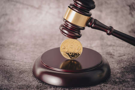 Cryptocurrency under judges gavel in foreground.の写真素材