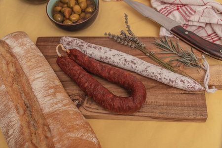 Spanish Fuet Salami and Fresh Sage on Rustic Wooden Cutting Board.