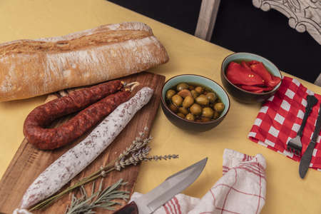 Spanish Fuet Salami and Fresh Sage on Rustic Wooden Cutting Board.の写真素材