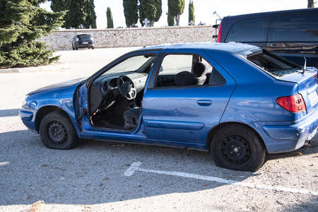 abandoned car in the middle of a car park. problem of abandoned waste not being processed as recycling.の写真素材