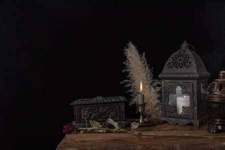 Dark still life with dried roses on wooden table.