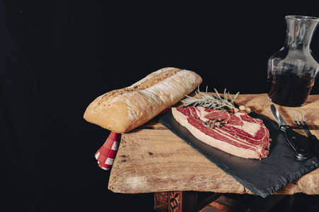 raw steak on pizarra dish isolated on black background.の写真素材