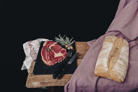 raw steak on pizarra dish isolated on black background.の写真素材
