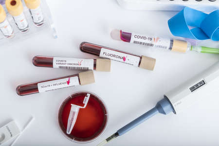 Blood samples of new variant OMICRON plus flu FLUORONE, covid19, coronavirus. Selective approach to the sample tube.の写真素材