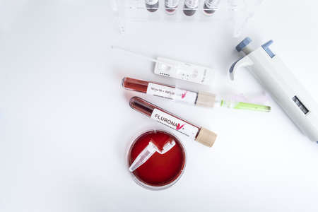 Blood samples of the new variant omicron plus flu FLURONA, covid19, coronavirus. Selective approach to the sample tube.の写真素材