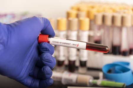Doctors hands hold blood samples of the new variant IHU, covid19, coronavirus. Selective approach to the sample tube.の写真素材