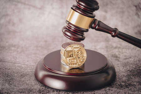 Cryptocurrency under judges gavel in foreground.の写真素材