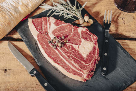 Variety of Raw Black Angus Prime meat steaks Machete, Blade on bone, Striploin, Rib eye, Tenderloin fillet mignon on wooden board.の写真素材