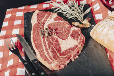 Raw beef filet mignon steaks with rosemary, pepper and salt on dark rustic board, black angus meat.の写真素材