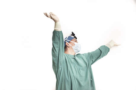 Female doctor face wearing protective mask and green surgeon cap closeup isolated on white background. Save patient life, copy space banner, laboratory, 911, medic help concept. Letterbox view.の写真素材