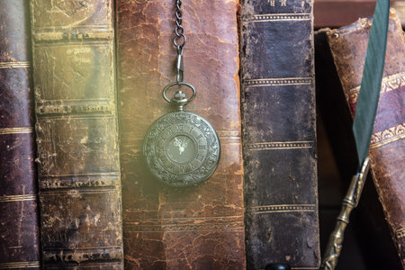 Classic still life with vintage books placed with old clock on rustic wooden background.