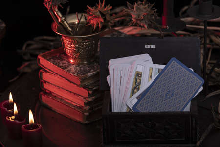 Tarot card spread on a nature display. Hand made tarot cards on a dark wooden table surrounded with dried herbs, blue flowers, white candles. Blue cards.の写真素材