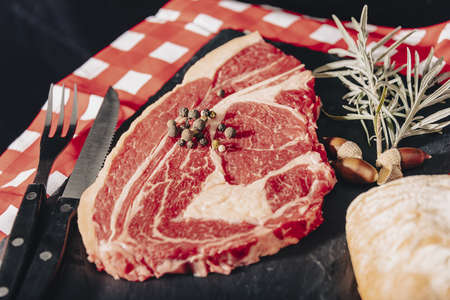 Raw beef meat on a dark wooden board.の写真素材