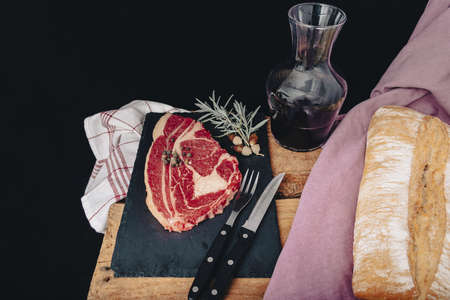 Raw beef meat on a dark wooden board.の写真素材