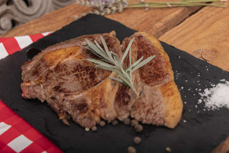 Beef on a slab of dark stone.の写真素材