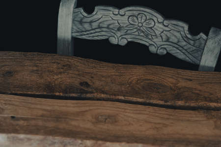 rustic table and chair with black background.の写真素材
