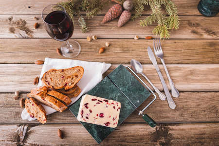 Delicious British Cheddar cheese with cranberry on a marble cheese cutting table.の写真素材