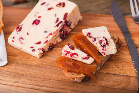 Wensleydale cheese with cranberries on a marble cheese cutting table.の写真素材