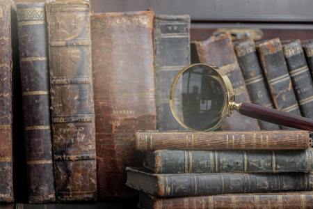 Vintage book and magnifying glass on wooden background.の写真素材