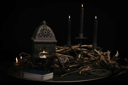 A fortune teller, witch stuff on a table, candles and fortune-telling objects. The concept of divination, astrology and esotericism.の写真素材